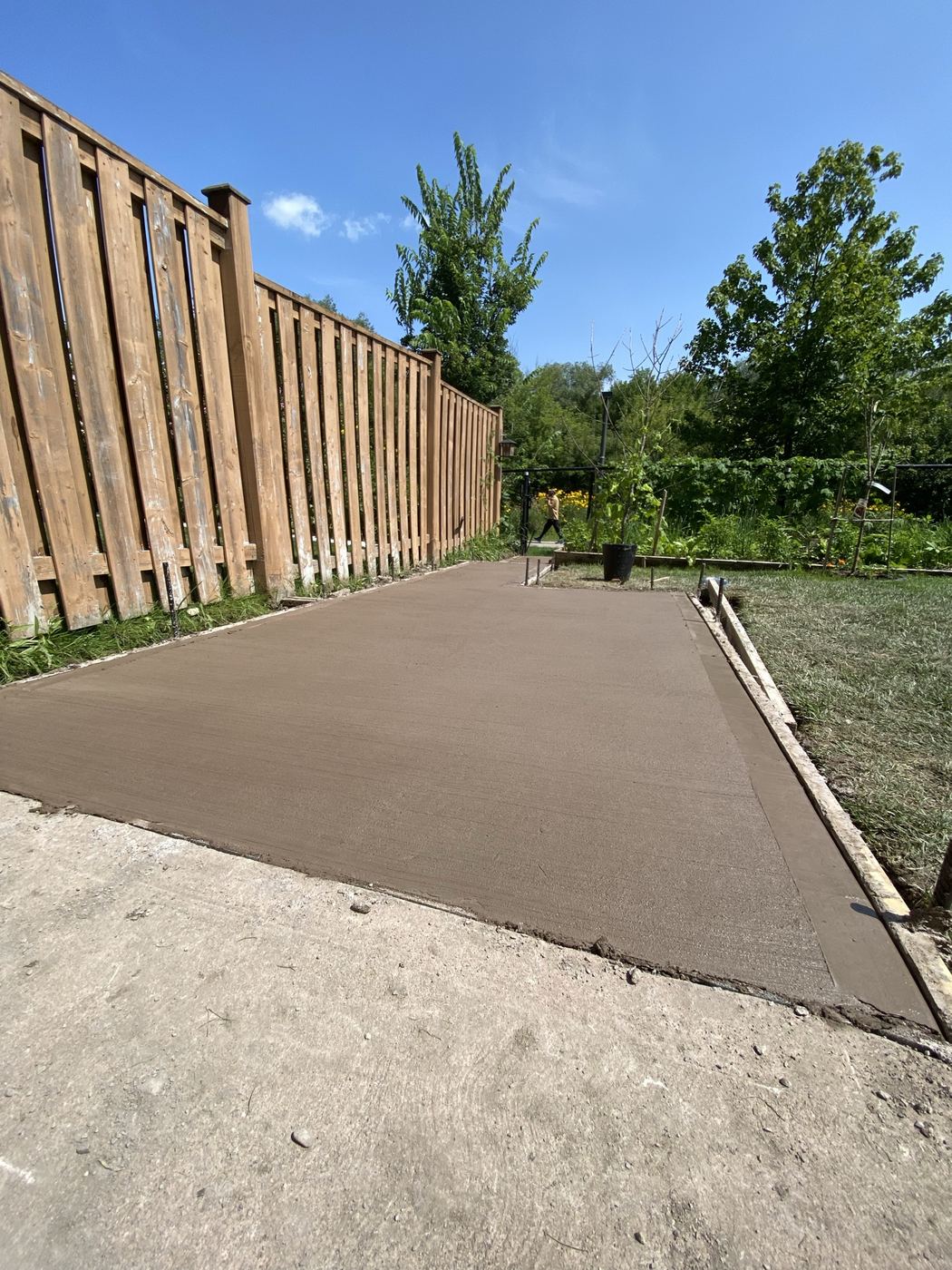 Fresh concrete slab beside a fence